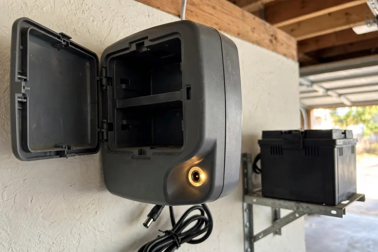 An opener's open battery compartment beside a separate add-on battery box, the backup port highlighted